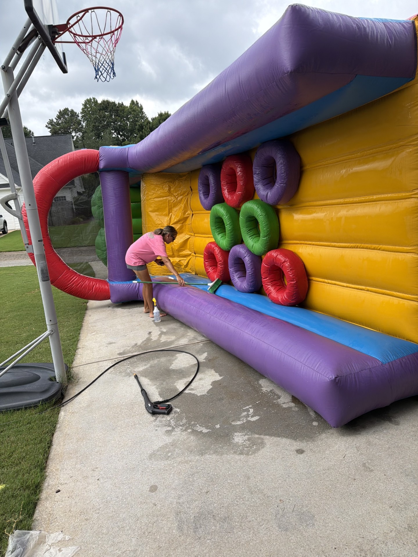 How We Clean Our Bounce Houses | Shindigz Event Rentals Newnan, GA 4 Shindigz Event Rentals staff scrubbing and sanitizing a bounce house between rentals in Newnan, GA
