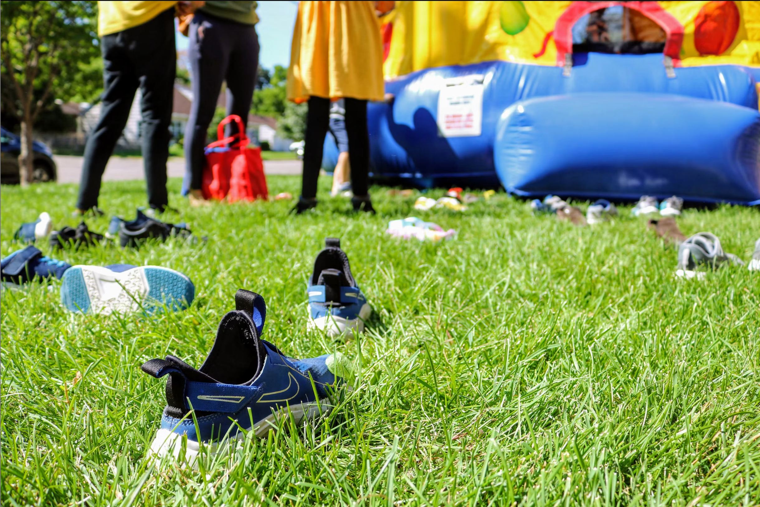 How We Clean Our Bounce Houses | Shindigz Event Rentals Newnan, GA 2 Pile of kids' shoes left outside a bounce house entrance at a party