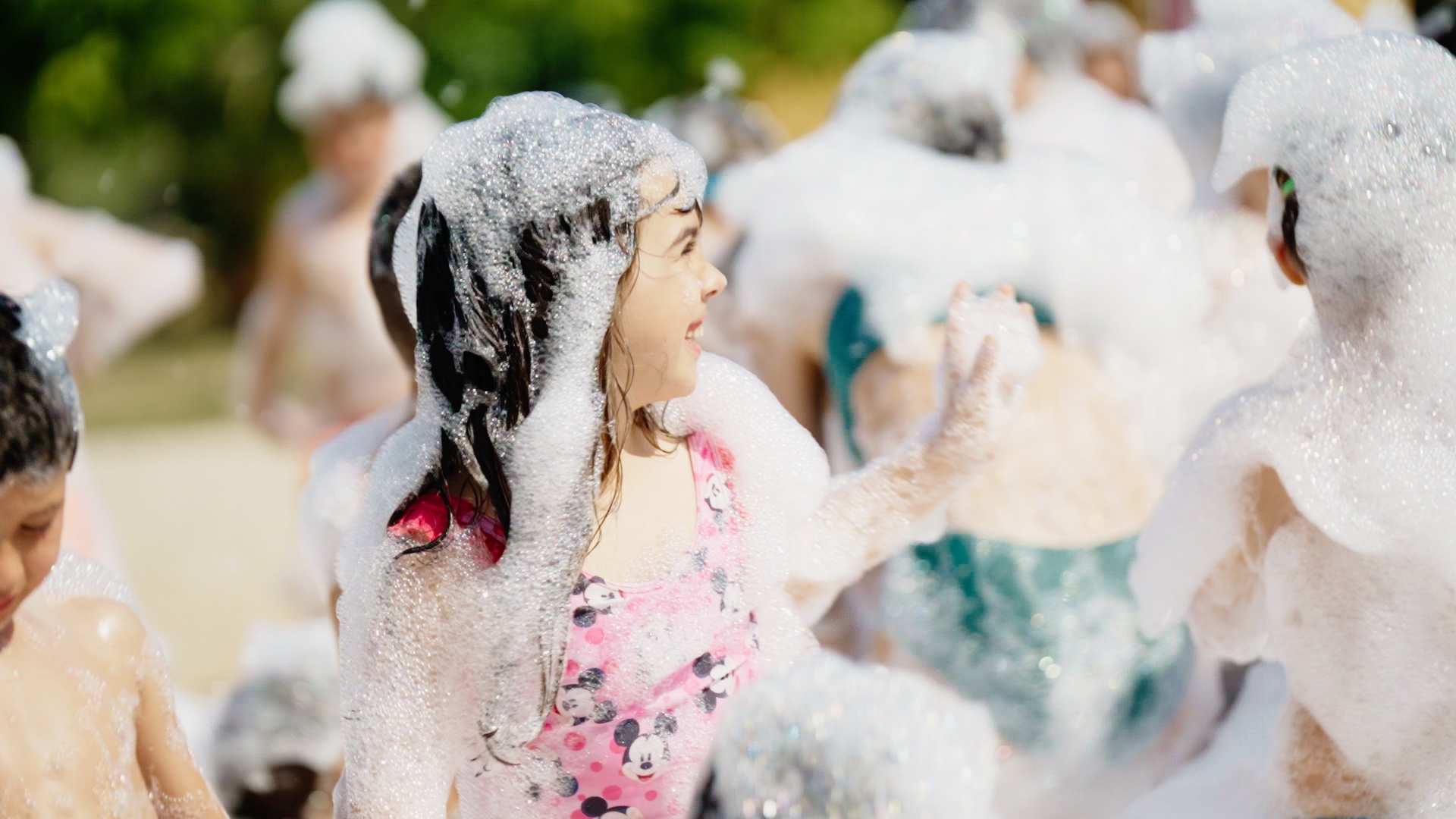 Girl covered in foam laughing at a foam party